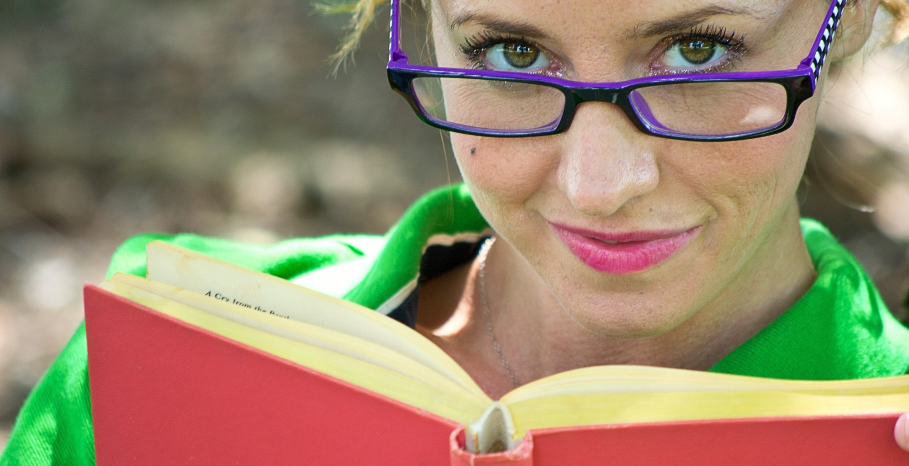 lady with violet eyeglasses reading a book