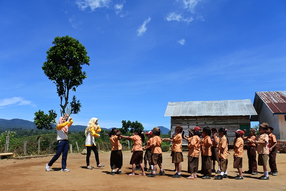 students lined up in front of 2 teachers